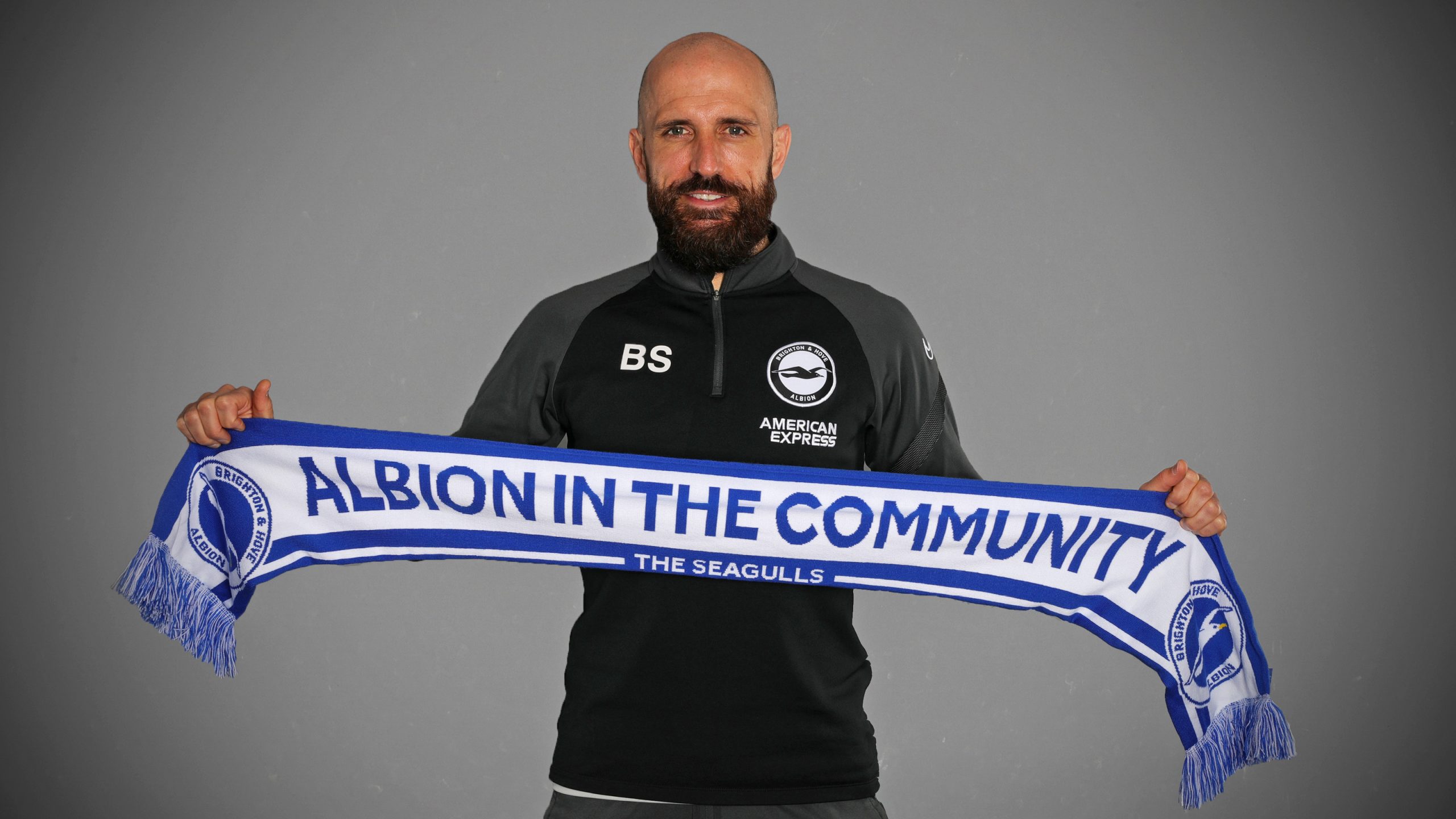 Bruno Saltor holding a Become a Community Champion scarf